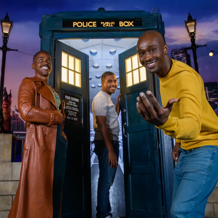 A man reaching out to the camera inviting you to join him, his son, and The Doctor into The TARDIS