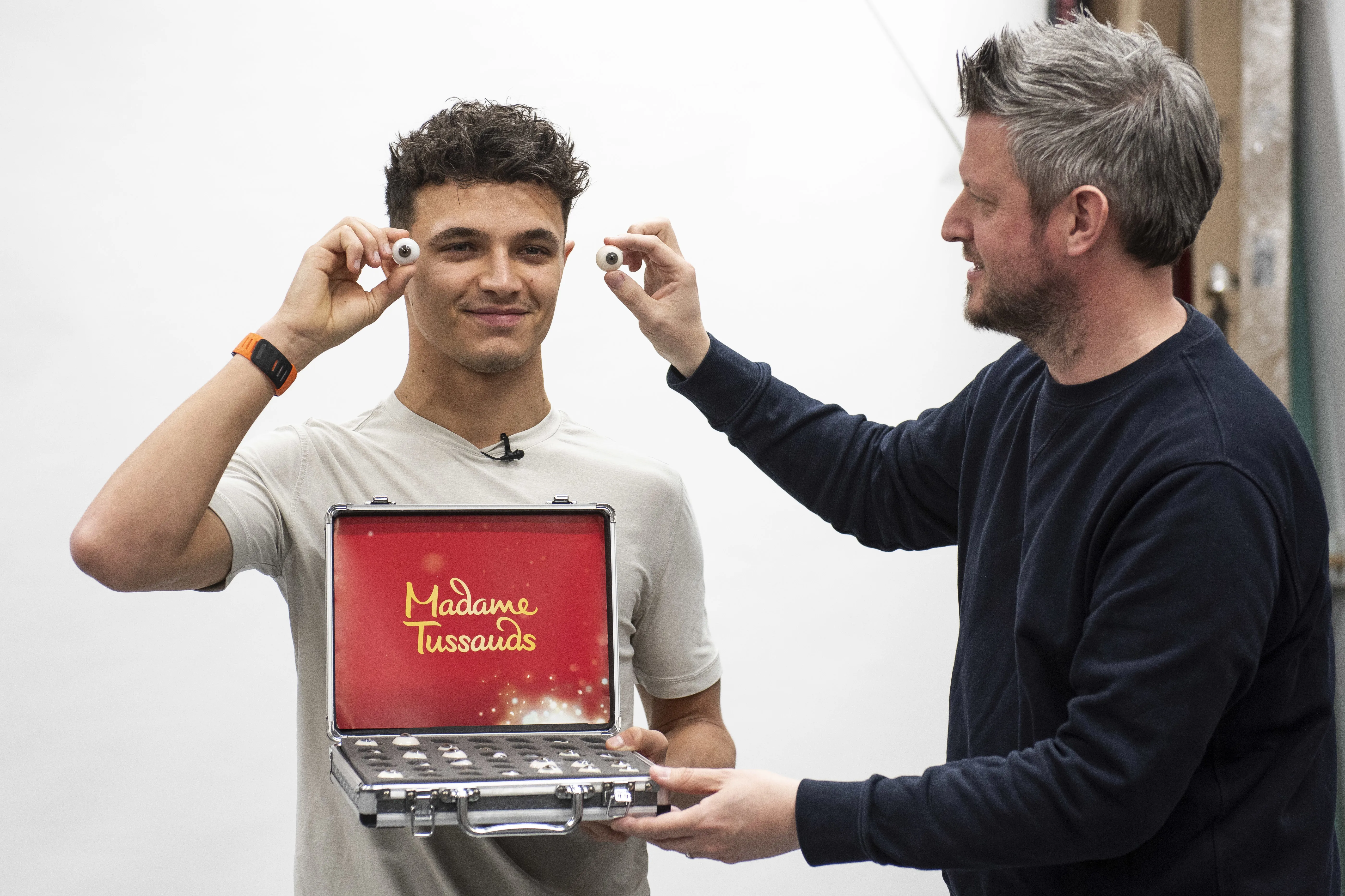 Lando Norris holding model eyes for his Madame Tussauds London wax figure